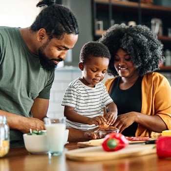 Parents preparing meal with child in kitchen