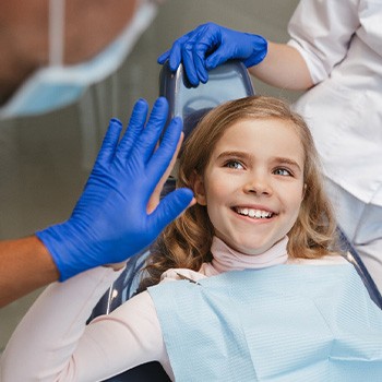 Child smiling and giving dentist a high five